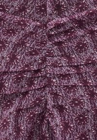 Țesătură mov cu un model abstract texturat, în nuanțe variate, cu detalii strânse de-a lungul cusăturilor.