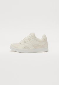 Sneaker alb cu un material texturat și un design din suede. Prezintă sisteme de prindere cu șireturi, vârf rotund și o talpă plată din cauciuc.