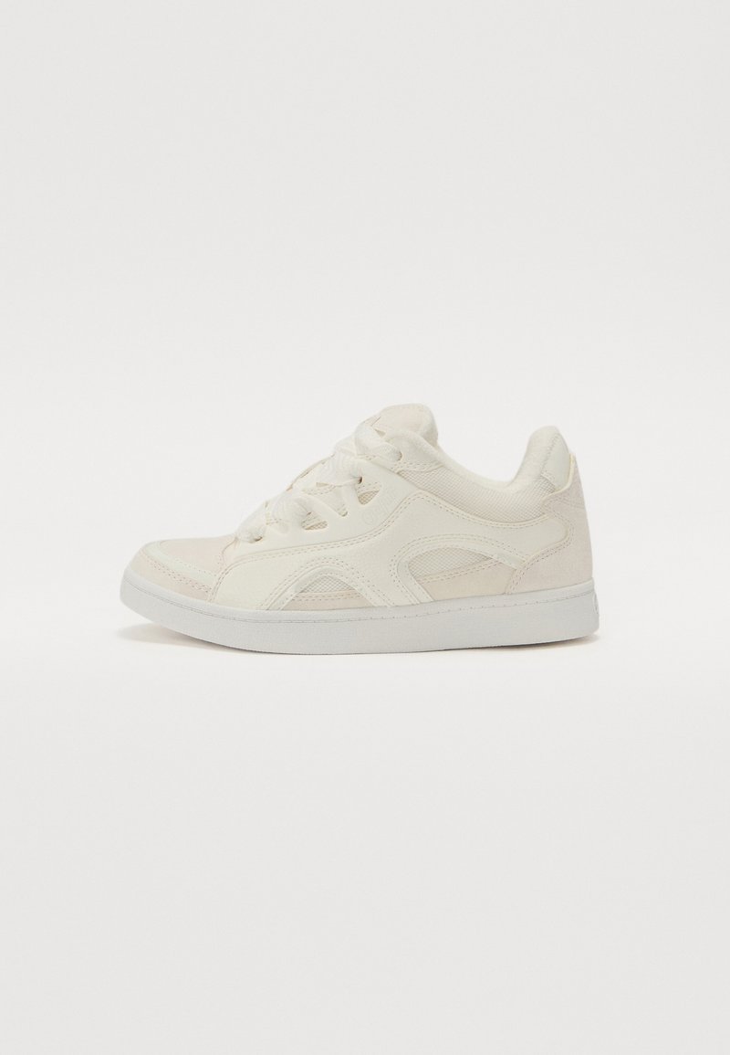 Sneaker alb cu un material texturat și un design din suede. Prezintă sisteme de prindere cu șireturi, vârf rotund și o talpă plată din cauciuc.