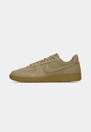 Sneaker beige a bassa, con suola in gomma, tomaia in suede e tessuto, lacci frontali e logo swoosh Nike sul lato.