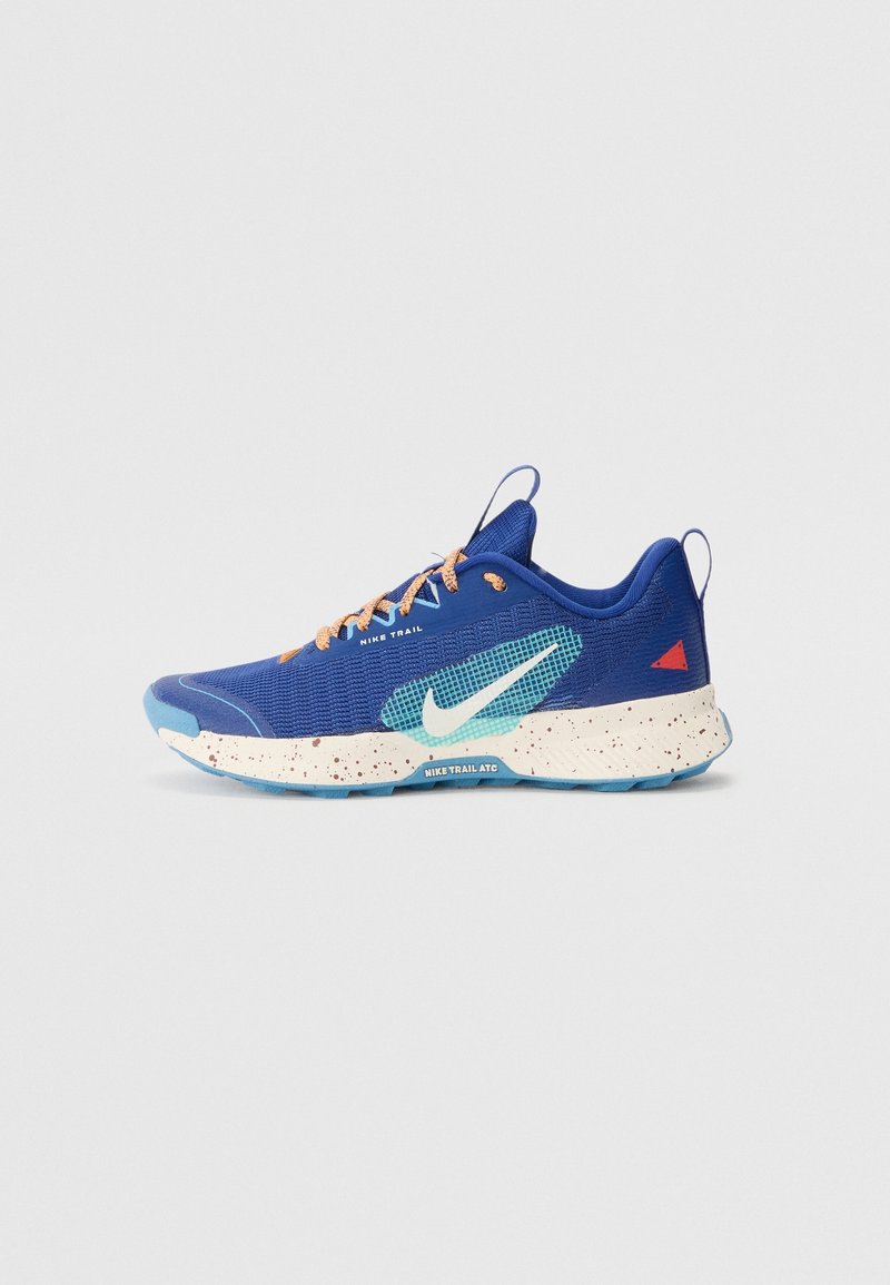 Chaussure de trail Nike bleu et turquoise avec semelle blanche tachetée, lacets orange et détail triangulaire rouge au talon.