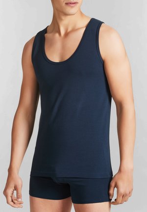 Top senza maniche di colore blu navy realizzato in tessuto liscio, con scollo ampio e aperture per le braccia, abbinato a pantaloni corti fitted dello stesso colore.