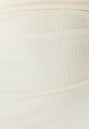 Roomkleurige textuurstof met een golvend patroon, voorzien van gelaagde plooien en een gladde afwerking. Zacht, lichtgewicht materiaal.