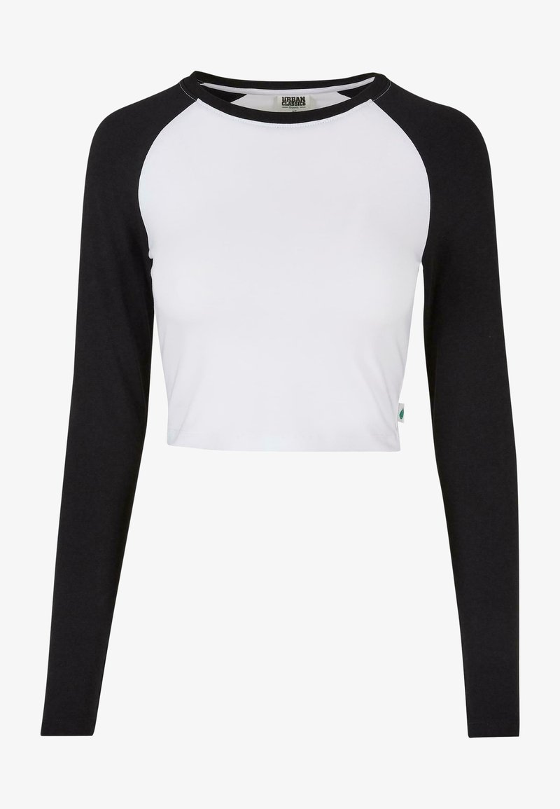 Svart och vit långärmad croptopp med raglanärmar. Tillverkad av mjuk bomullsblandning, med rund halsringning och logotyp Tagg på fållen.
