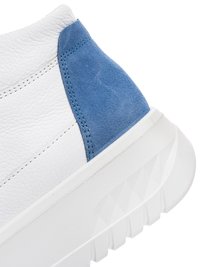 White leather sneaker heel with blue suede patch and thick white textured sole, shown on a white background.