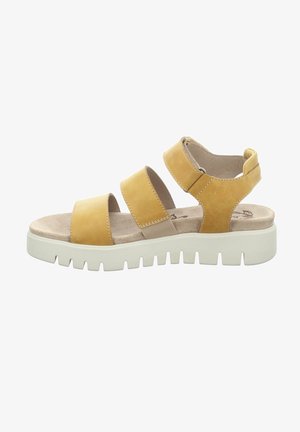 Gelbe Leder-Sandale mit drei breiten Riemen, einer gepolsterten Fußbett und einer dicken weißen Gummisohle mit einem strukturierten Griffmuster.