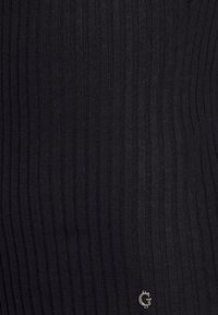Tissu noir à côtes avec un motif vertical. Présente un petit accent du logo argenté "G". Le matériau semble doux et texturé.