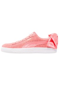 Sneaker in suede rosa con suola in gomma bianca, caratterizzata da un fiocco in satin sul tallone, un sistema di lacci e dettagli testurizzati sul lato.