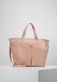 Vaaleanpunainen nahkainen olkalaukku, jossa on jämäkkä muotoilu, kaksinkertaiset yläkahvat ja kullanväriset metalliosat. Edessä kaksi taskua lisäämään käytännöllisyyttä.