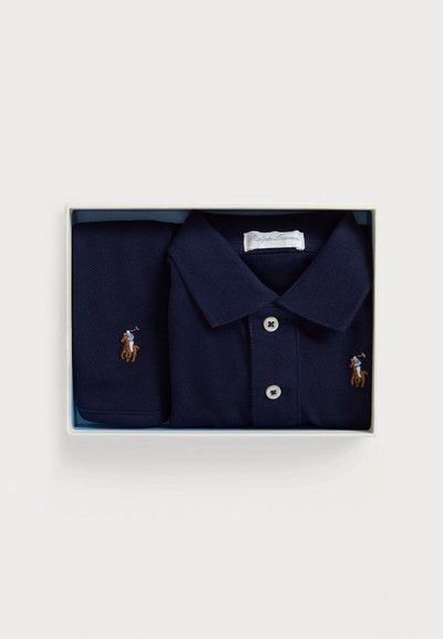 Tmavomodré polo tričko a zodpovedajúca vreckovka v krabičke, s gombíkmi na zapínanie, golierom a vyšívaným logom hráča póla na koni.