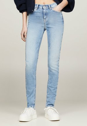 Jeans skinny de denim de lavado claro con cintura alta, que cuentan con un diseño clásico de cinco bolsillos, cierre de cremallera y sutiles detalles de desgaste.