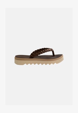 Brun flip-flop med tyk beige sål og flettede stropper, tekstureret fodseng og brandnavn på stroppens side.