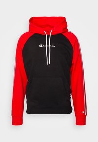 Felpa nera e rossa con tasca frontale, cordini bianchi e logo "Champion". Caratterizzante per maniche raglan a contrasto e strisce laterali.