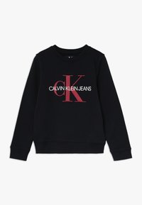 Sudadera negra con un gran logo rojo "CK" y el texto "CALVIN KLEIN JEANS" en blanco, con un cuello redondo clásico y mangas largas.
