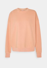 Sudadera de color durazno hecha de una mezcla de algodón, con cuello redondo, mangas largas y un sutil logo bordado en el pecho.