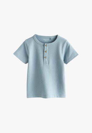 Hellblaues kurzärmeliges T-Shirt mit rundem Ausschnitt und drei hölzernen Knöpfen vorne, gefertigt aus strukturiertem Stoff.