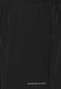 Svarta sportshorts i lättviktsmaterial, med elastisk midja och en reflekterande "ENDURANCE"-logotyp på den nedre sidan.