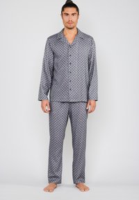 Grijze gemusterde pyjama-set met een knoopsluiting en lange mouwen, en bijpassende broek, gemaakt van zachte stof met een subtiel geometrisch ontwerp.