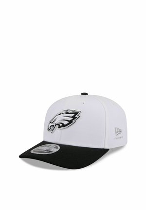 White and black baseball cap with a black visor, featuring a black and white eagle logo on the front and New Era branding on the side.