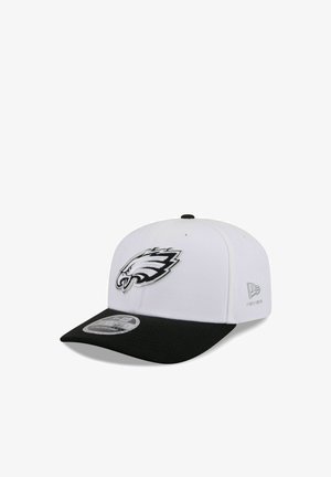 White and black baseball cap with a black visor, featuring a black and white eagle logo on the front and New Era branding on the side.
