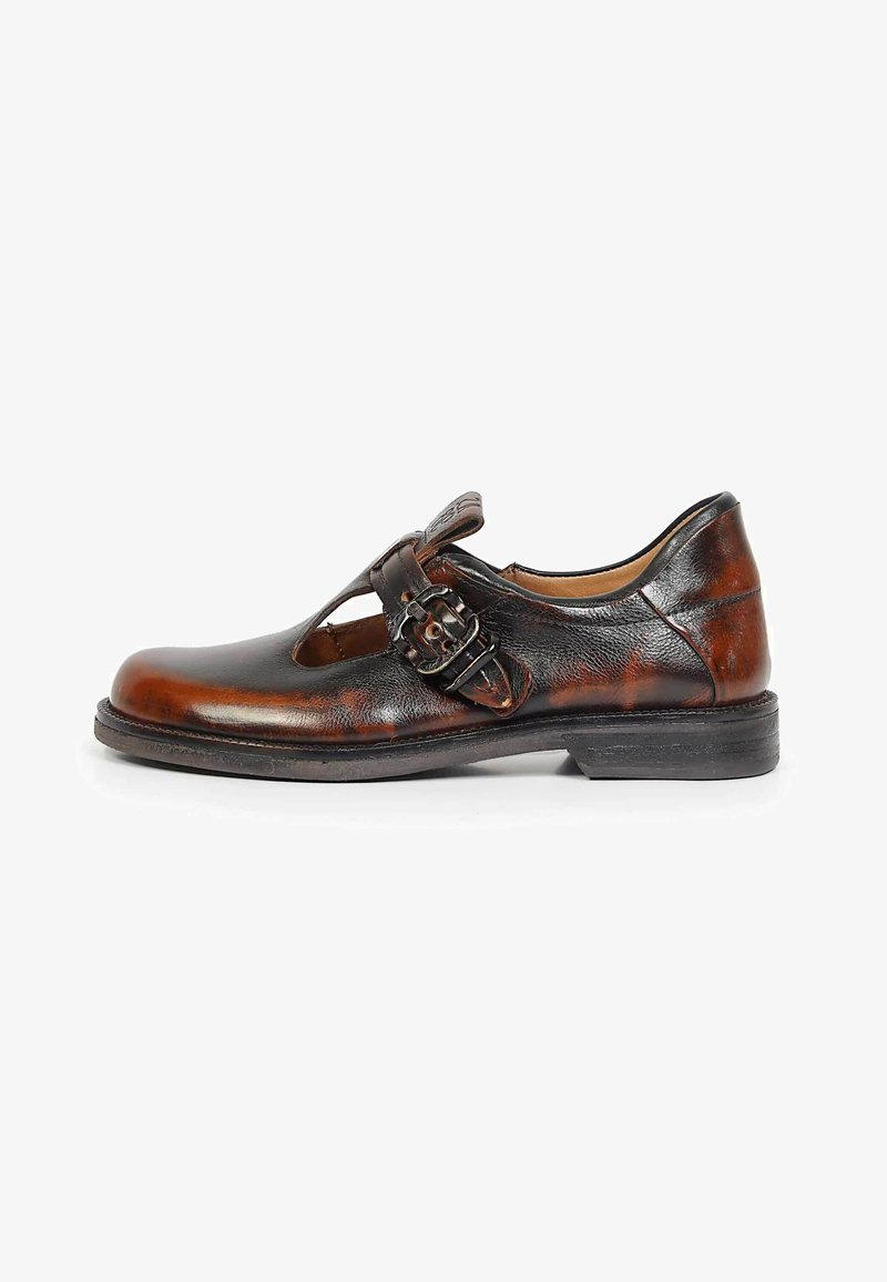 Chaussure habillée pour homme en cuir marron avec une bride à boucle et un design ajouré, comprenant une semelle basse noire et un bout arrondi.