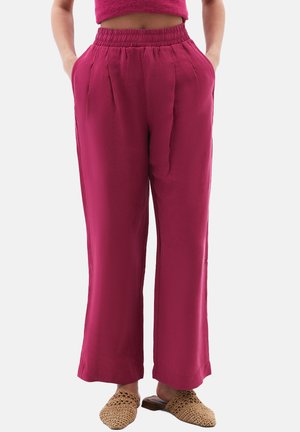 Fuchsia wijde pantalon met een hoge elastische tailleband, voorzien van plooien aan de voorkant en zijzakken. Draagt bij textured instappers.