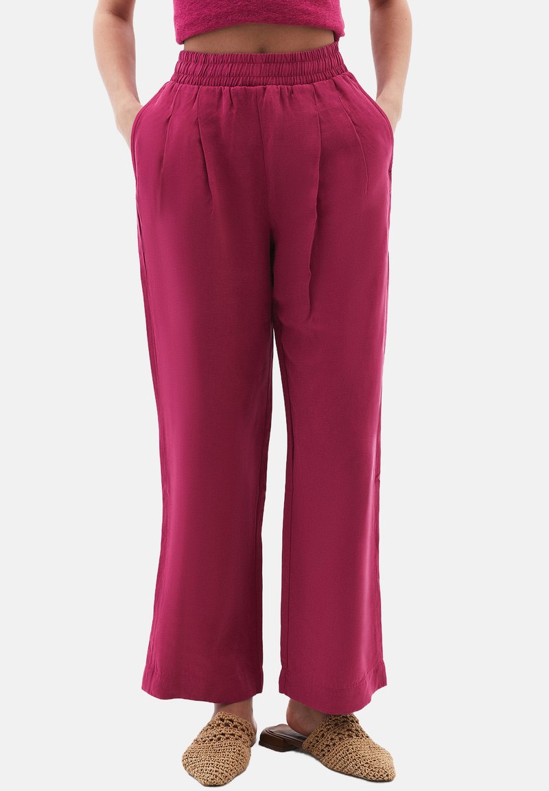 Fuksia laaja-housut korkealla joustavalla vyötäröllä, joissa on etupleitejä ja sivutaskuja. Yhdistetty teksturoituihin liukuvaan kengät.