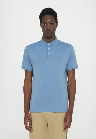 Blauwe polo met een kraag, korte mouwen en een klein logo op de linkerkant van de borst. De stof lijkt glad en lichtgewicht.