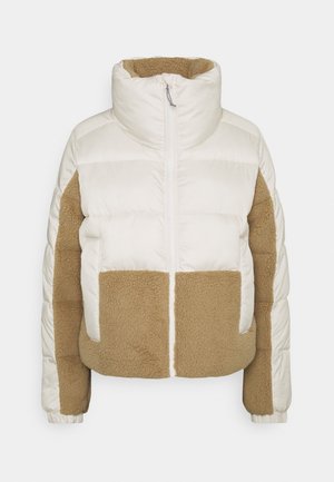 Veste matelassée blanche et beige avec col montant, fermeture éclair avant et panneaux en polaire beige sur les manches et le bas devant.