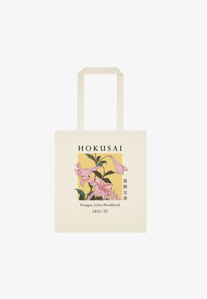 Canvas taske med illustration af pink trompetliljer, tekst "HOKUSAI," og "Trumpet Lilies Woodblock 1831/32" på en gul baggrund.