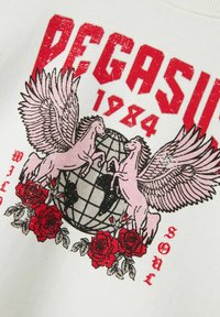 Hvid sweatshirt med et grafik af to lyserøde vingede heste oven på en klode, omgivet af røde roser. Teksten lyder "PEGASUS 1984 WILD SOUL."
