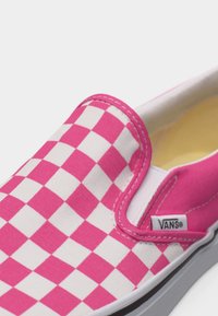 Scarpa slip-on Vans a quadretti rosa e bianchi con suola bianca e etichetta del marchio visibile sul lato.