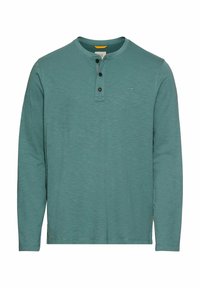 Langærmet henley skjorte i teal, med rund hals, tre knaplukninger og subtil tekstur. Lille logo på brystet.