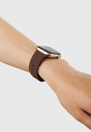 Smartwatch mit braunem Armband und roségoldenem Gehäuse, getragen am linken Handgelenk einer Person vor hellgrauem Hintergrund.