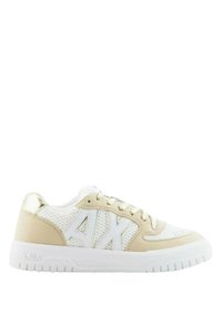 Sneaker beige e bianco con pannelli in rete e pelle, caratterizzata da una suola in gomma bianca, dettagli dorati e un logo prominente sul lato.