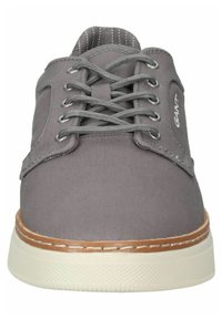 Gray canvas sneaker with round toe, lace-up design, light tan sole, and subtle stitching detail along the edges.