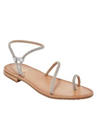 Sandale plate beige avec de fines lanières argentées scintillantes. Dispose d'un doigt de pied en boucle et d'une semelle marron clair. Design simple avec un minimum de embellissements.