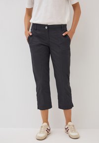 Pantaloni neri a vita alta in tessuto leggero, con tasche laterali e vita elasticizzata, caratterizzati da un bottone frontale e dettagli cuciti.