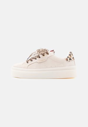 Hvid platforme-sneaker med leopardprint snørebånd og hæl, guldøjer og en tyk hvid sål, set fra siden på hvid baggrund.