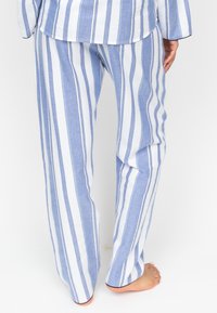 Blauwe en witte gestreepte pyjamabroek van lichtgewicht stof, met een rechte snit en zoom, en een elastische tailleband.