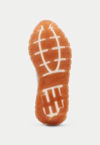 Gummisohle eines Sneakers mit einem gemusterten Profil. Orangefarben mit weißen Akzenten und Branding. Strapazierfähige und strukturierte Oberfläche für besseren Halt.