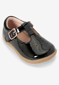 Schwarzer Lacklederschuh mit T-Riemen-Design, Schnallen-Detail, durchbrochenen Akzenten an der Zehe und einer beigen Gummisohle.