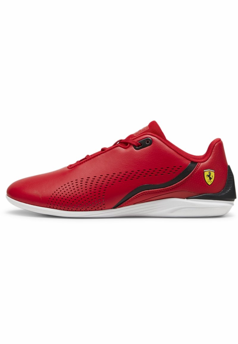 Baskets basses rouges avec détails noirs, côté perforé, semelle blanche et logo Ferrari jaune près du talon.