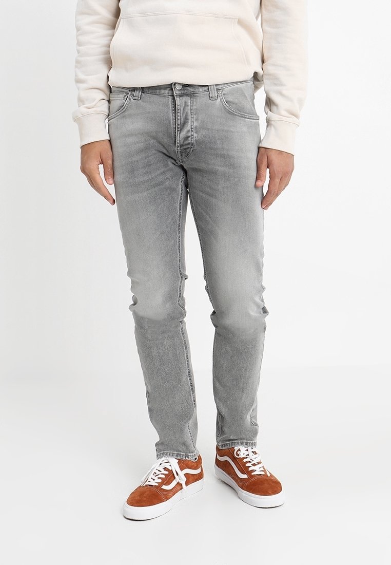 Grå denimjeans med slim fit, med en blekt tvätt, femficksdesign och kontrastsöm; bärs med bruna mockasneakers.