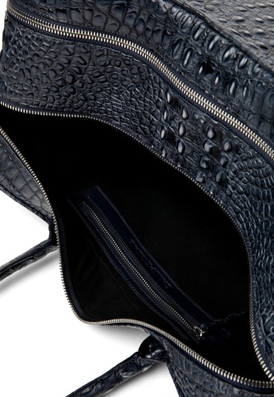 Sac en cuir noir à texture crocodile ouvert, montrant un compartiment intérieur zippé et une fermeture éclair argentée.