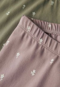 Set di abbigliamento da loungewear in cotone di colore verde oliva e mauve, caratterizzato da delicati stampati floreali bianchi e una vita elasticizzata per il massimo comfort.