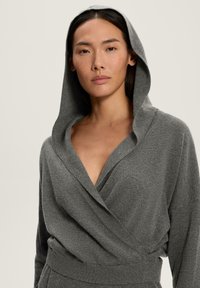 Sweatshirt căptușit gri cu un design tip wrap, având o decolteu adânc în formă de V și un material moale, texturat. Accentuat de un brâu ajustat.