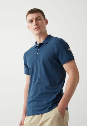 Polo shirt blu navy realizzato in tessuto morbido, con un colletto, patta con tre bottoni, maniche corte e una toppa con logo sulla manica.