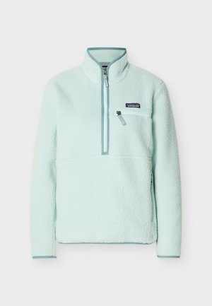 Lyseblå fleecegenser med kvart-glidelås, høy krage, glidelåslomme på brystet og Patagonia-logo på venstre bryst.