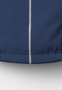 Mørkeblåt stof med en glat tekstur, prydet med en lodret sølvstribe langs kanten. Rene, skræddersyede kanter og ingen synlig hardware.